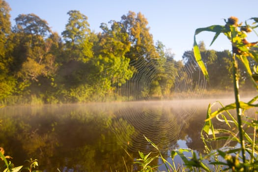 sunrise over the quiet summer river in fog