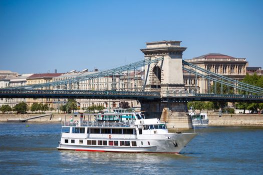 Cruise ships on Danube river with Chain Bridge in front  and Parliament Building in the background, Budapest.
