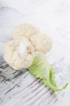 Fresh raw cauliflower isolated on white wooden background. Healthy raw food eating. Vegetable background, country style.