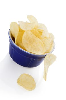 Delicious potato chips in bowl isolated on white background. Contemporary minimal style. Unhealthy eating.