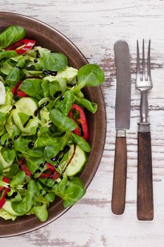 Fresh salad background. Corn salad, capsicum and cucumber on plate, top view. Fresh summer healthy eating.