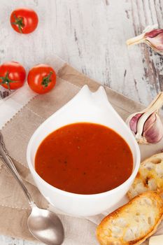 Delicious tomato soup background with toasted baguette, tomatoes and garlic. Culinary healthy delicious vegetarian eating.