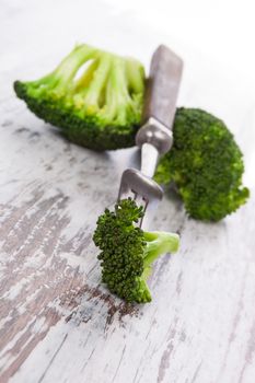 Delicious raw broccoli on white wooden background. Healthy raw food diet concept.