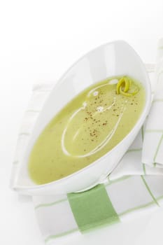 Delicious leek soup in white modern bowl isolated on white background. Culinary healthy eating.