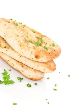 Culinary naan flatbread stack with fresh parsley isolated on white background. Traditional eastern bread eating.