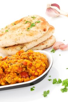 Delicious dal in bowl with naan flat bread and fresh herbs isolated on white background. Culinary eastern cuisine. 