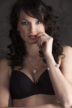 close up portrait of a brunette with make up and hair style in black bra and red lips