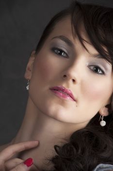 close up portrait of young brunette looking in camera on dark background