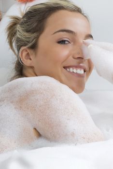 nice close up of a blond girl in bathtub with foam all around in relax