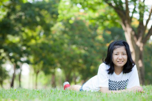 Asian teen girl. Are lying on the grass in the park.