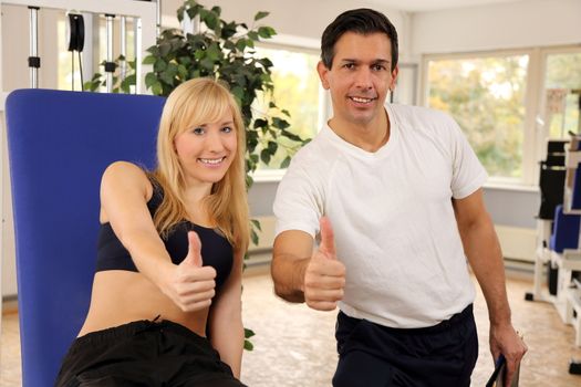 Personal trainer and athletic woman working out in a fitness center