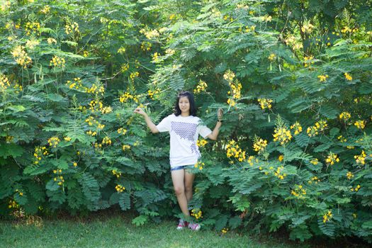 asian girl and yellow flower in park.actie smile and relax.