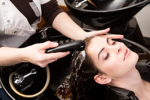 Beautiful woman washing her hair in hairsalon