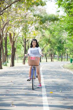 Young woman bicycling. Within the park. The space allocated for bicycling in particular.