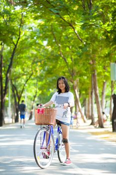 Young woman bicycling. Within the park. The space allocated for bicycling in particular.