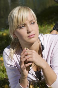 cute blond girl outdoor in a sunny day listening music from mp3