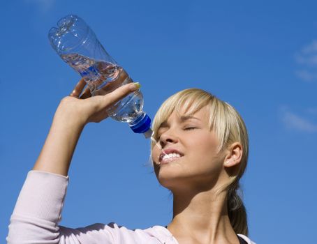 cute blond girl drinking water from a sport bottle