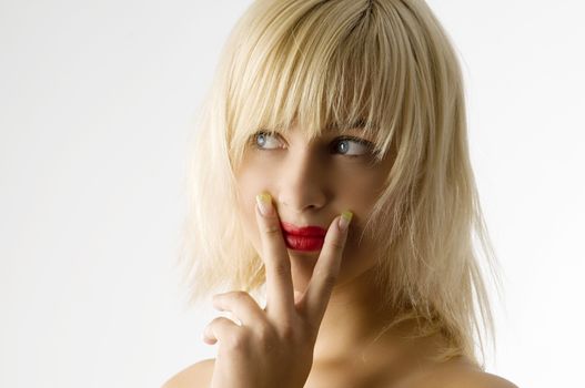 fashion portrait of blond girl with red lips and finger near mouth