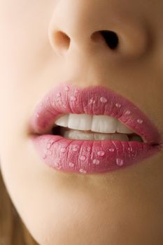 close up of pink woman mouth with little water drops on lips