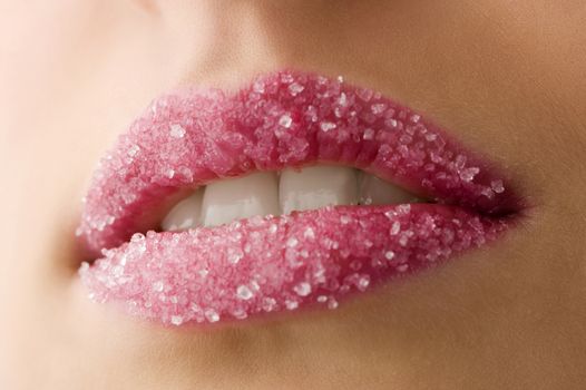 Woman's red lips coated with scattered sugar showing tooth