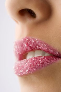 Woman's red lips coated with scattered sugar