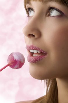 Pretty young girl with sugar on lips and a lollipop looking up