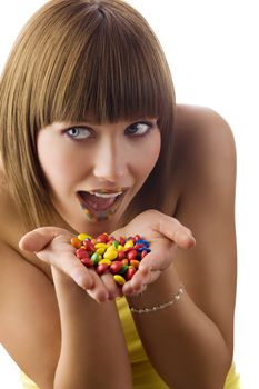nice girl glancing on one side with colored lips and smarties in hand
