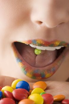 close up of a mouth with multicolor lips and colored smarties