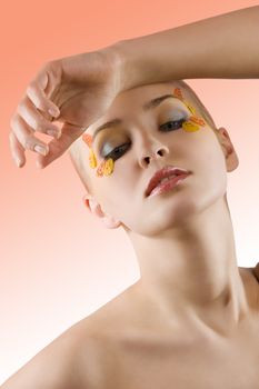 very nice and young blond model posing with a creative colored make up on white