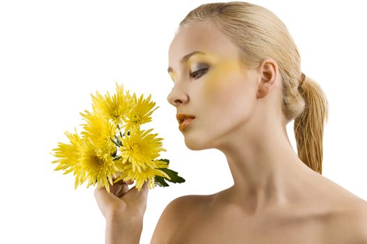 profile shot of cute blond girl looking at some yellow flowers. wellness concept