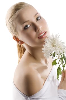 beauty portrait of young cute blond girl with white top and some flowers near face