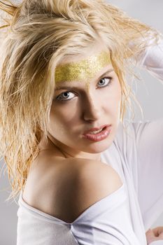 close up portrait of very cute blond girl with wet hair and a creative golden and shining make up