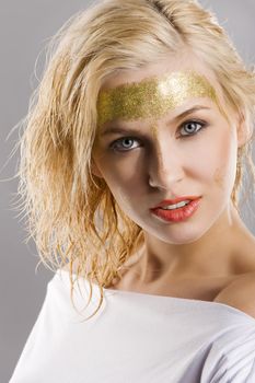 very cute blond girl with wet hair and a creative golden and shining make up