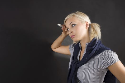 pretty young college student near the empity blackboard in act to think