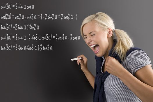 nice school girl in panic , screaming in front of the blackboard, during a math lesson