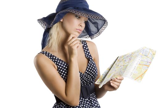 elegant woman in blue polka dot dress and hat looking at a tourist map