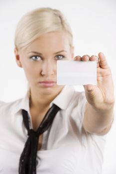 pretty young blond woman in white shirt and scarf like a tie showing a white card.FOCUS ON THE CARD