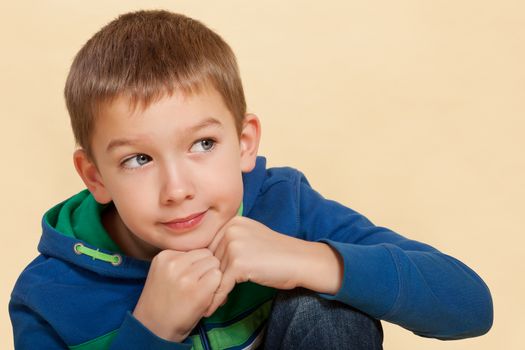 Young cute boy 10 years old isolated, thinking about ending childhood, school and a new brother. Facial expressions concept.