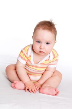 Cute baby girl, 9 month old with big blue eyes sitting isolated on white background. Happy baby. 