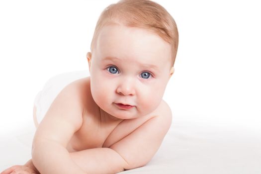 Cute baby girl with big blue eyes lying with diaper isolated on white background. 