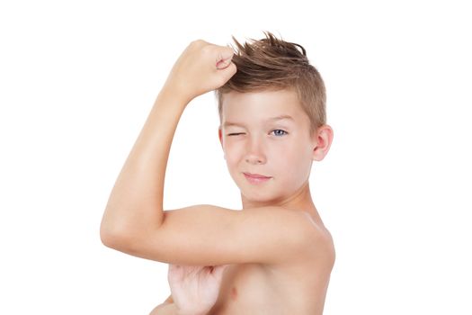 Charming young shirtless blinking boy showing biceps isolated on white background. Funny morning hygiene concept.