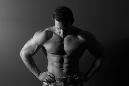 Sexy muscular bodybuilder isolated. Black and white fine art portrait.