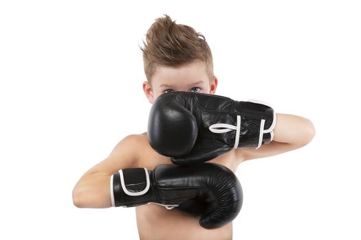 Charming boy with boxing gloves protecting his face isolated on white background. Sport and fitness.