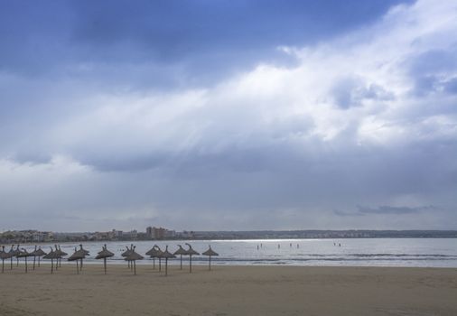 November scene in Playa de Palma with parasols, paddle surfers and hotels around the bay in late afternoon beautiful light.