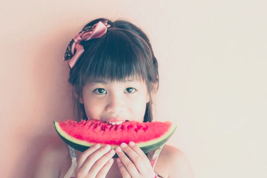 Cute little asian girl eating watermelon, use filtered images 