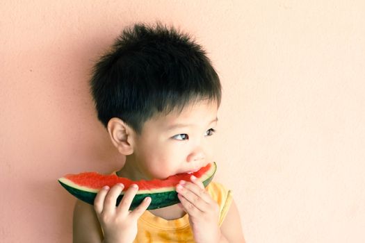 Lovely Asian boy eating watermelon, use filtered images 