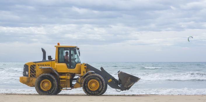 Yellow Power Shovel doing work on the beach of Playa de Palma in November.