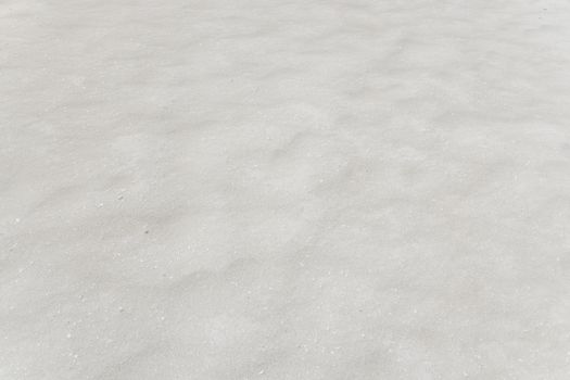 Wind blown sand creating little micro-dunes on a beach. Texture background.