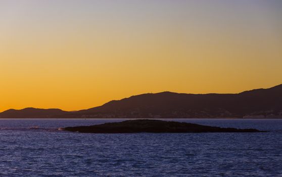 November sunset Palma bay with yellow sky and blue sea. Palma de Mallorca, Balearic islands, Spain.