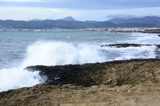 Wave Palma Bay. Fresh foamy wave crashing onshore. Cala Estancia, Mallorca, Balearic islands, Spain in November.